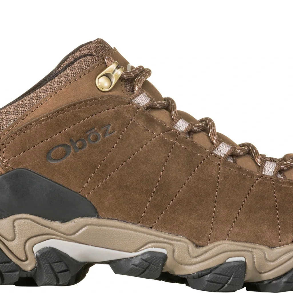 Brown hiking shoe with black sole on a white background