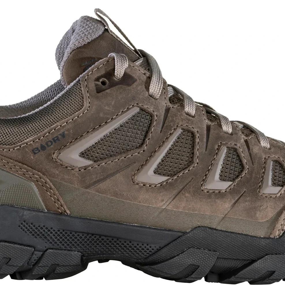 Brown hiking shoe with black sole on a white background