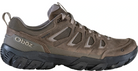 Brown hiking shoe with black sole on a white background
